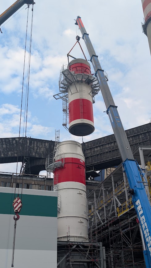 Autojeřáb a lešení u ocelového komína v energetickém areálu v Ústeckém kraji