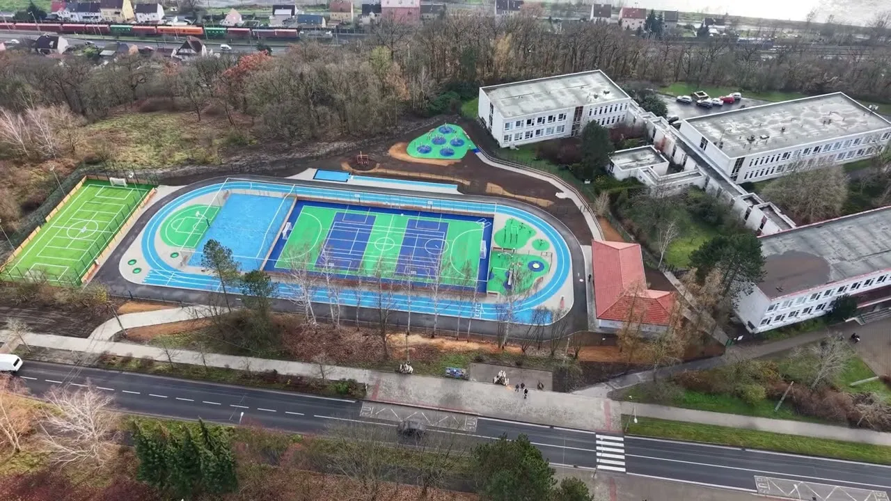 Sportovní areál s atletickou dráhou a hřišti natočený dronem z výšky